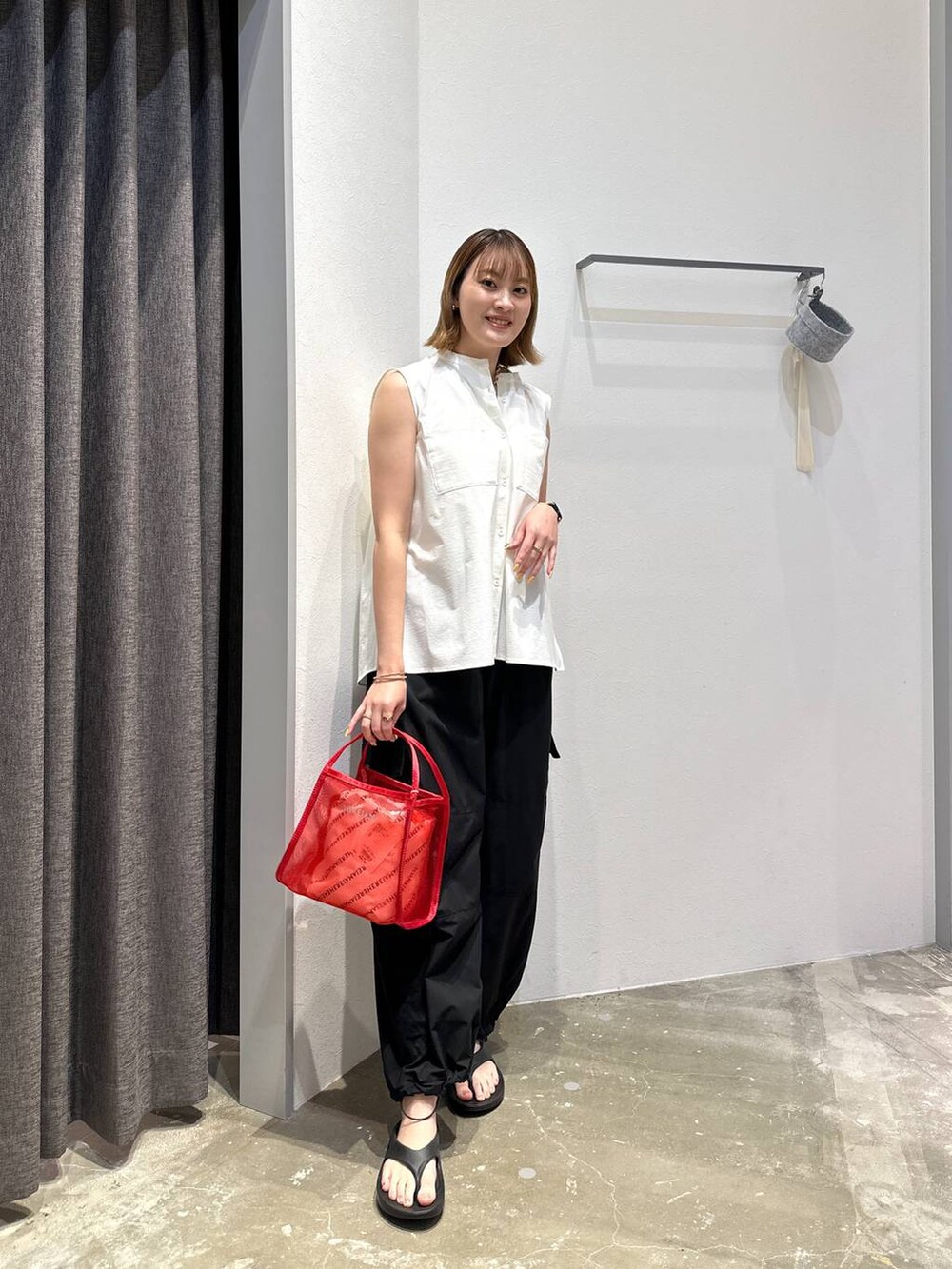 レッド系のハンドバッグ、ホワイト系のシャツ/ブラウス、ブラック系のその他パンツを着用したレディースの夏コーディネートの4枚目の写真