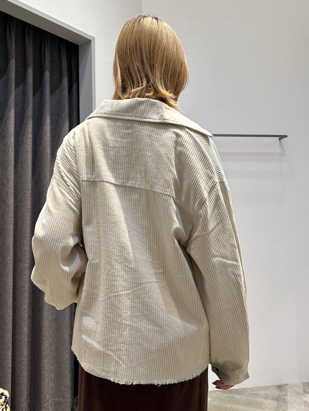 ブラウン系のスカート、ホワイト系のTシャツ/カットソー、ホワイト系のブルゾンを着用したレディースの秋コーディネートの7枚目の写真