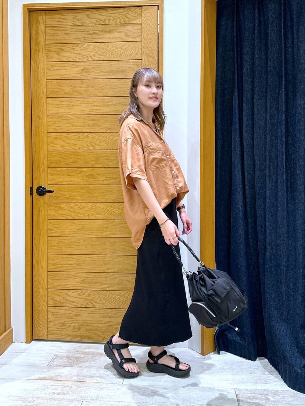 ブラック系のスカート、ブラック系のサンダル、レッド系のシャツ/ブラウスを着用したレディースの夏コーディネートの2枚目の写真