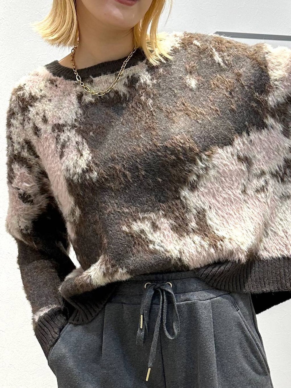 ブラウン系のニット/セーター、グレー系のスウェットパンツを着用したレディースの冬コーディネートの5枚目の写真