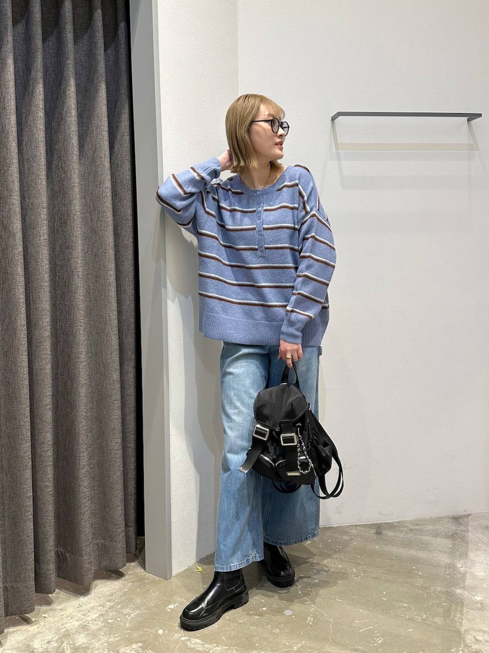 ブルー系のニット/セーター、ブルー系のデニムパンツ、ブラック系のバックパック/リュックを着用したレディースの冬コーディネートの9枚目の写真