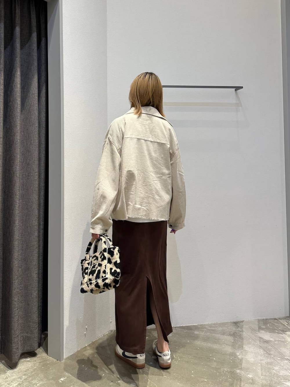 ブラウン系のスカート、ホワイト系のTシャツ/カットソー、ホワイト系のブルゾンを着用したレディースの秋コーディネートの3枚目の写真