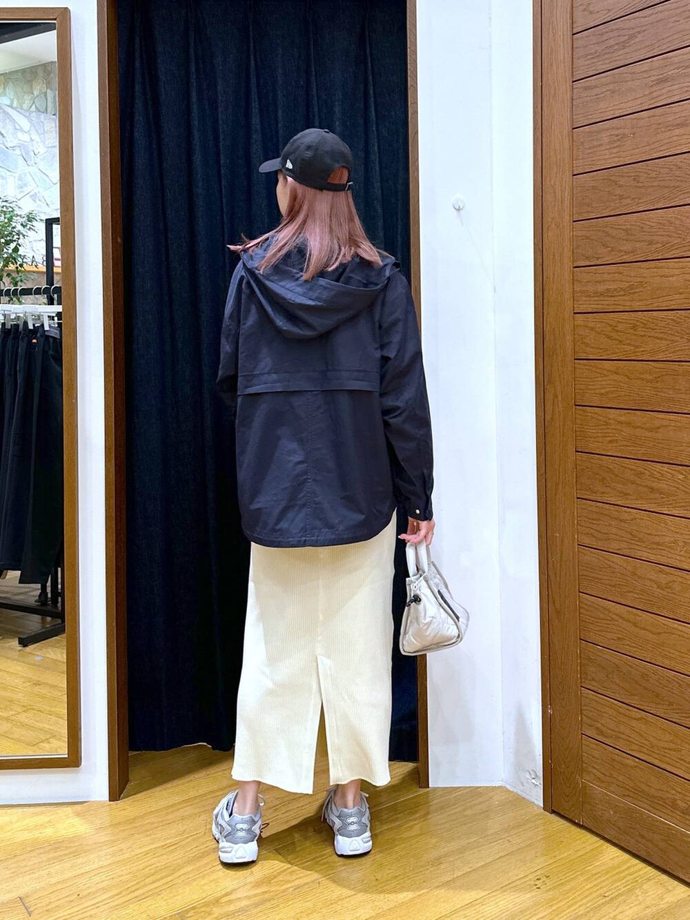 ベージュ系のスカート、ブルー系のマウンテンパーカー、ホワイト系のショルダーバッグを着用したレディースの秋コーディネートの3枚目の写真