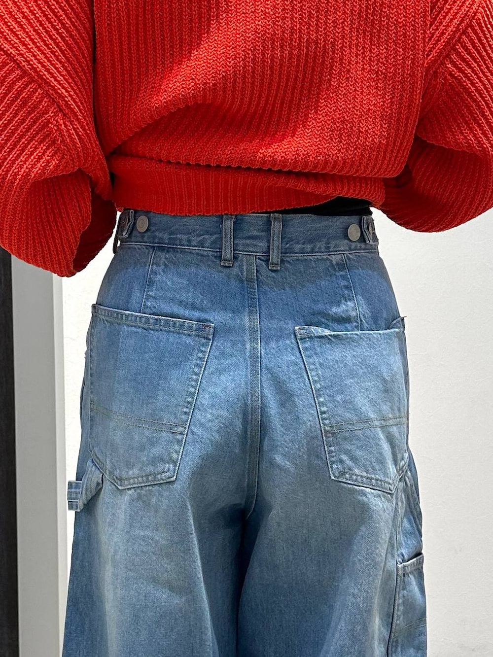 ブルー系のデニムパンツ、レッド系のニット/セーター、ブラック系のバックパック/リュックを着用したレディースの冬コーディネートの8枚目の写真