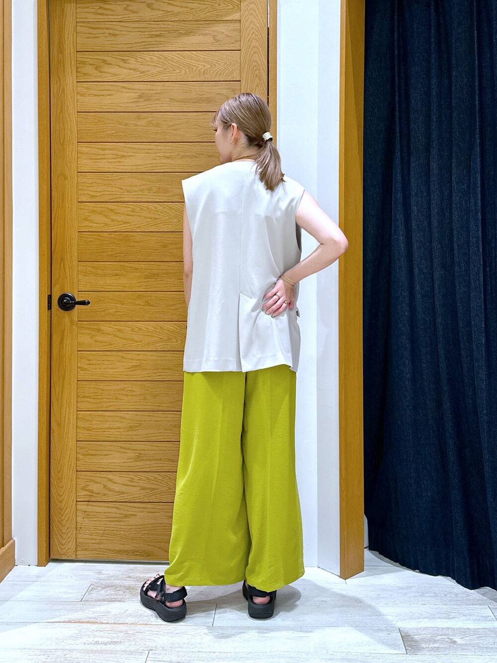 ホワイト系のTシャツ/カットソー、ベージュ系のベスト、ブラック系のサンダルを着用したレディースの夏コーディネートの3枚目の写真