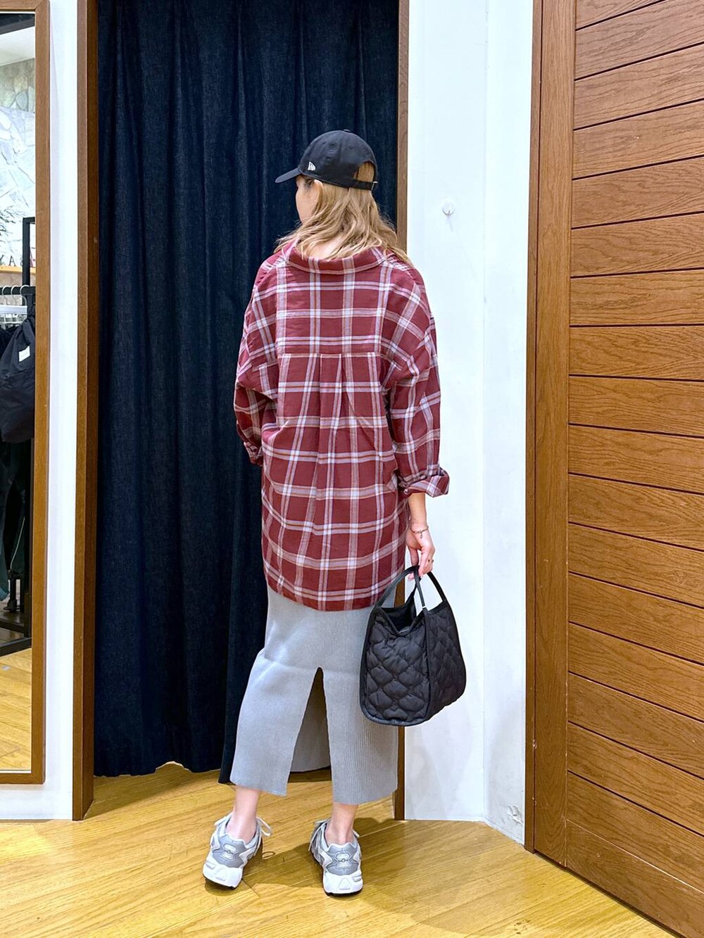 レッド系のシャツ/ブラウス、ブラック系のハンドバッグ、グレー系のスカートを着用したレディースの秋コーディネートの3枚目の写真