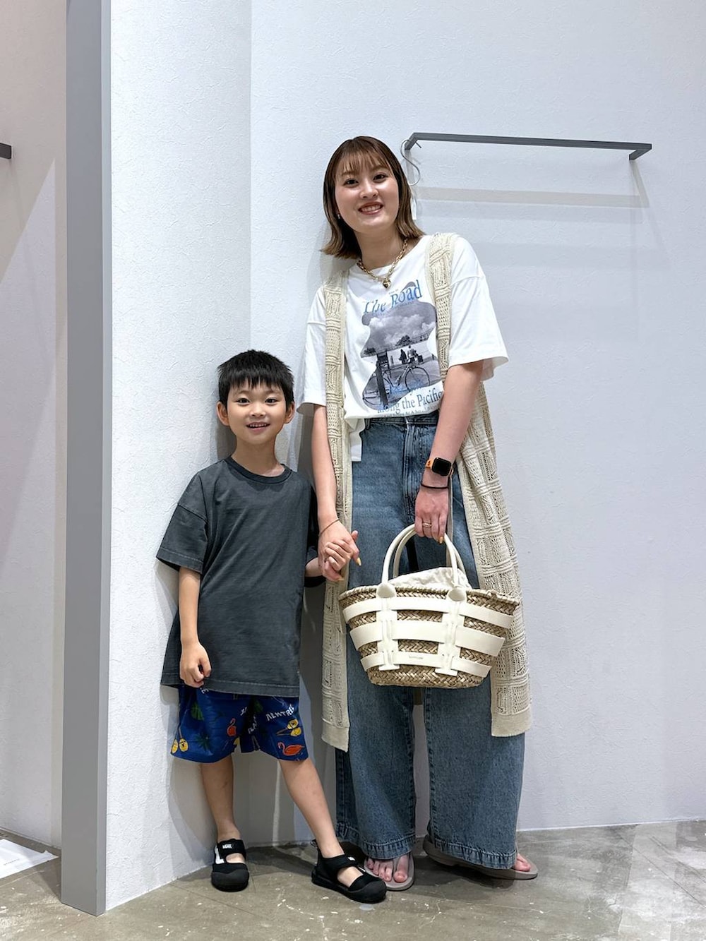 ベージュ系のサンダル、ホワイト系のかごバッグ、ブルー系のデニムパンツを着用したレディースの夏コーディネートの3枚目の写真