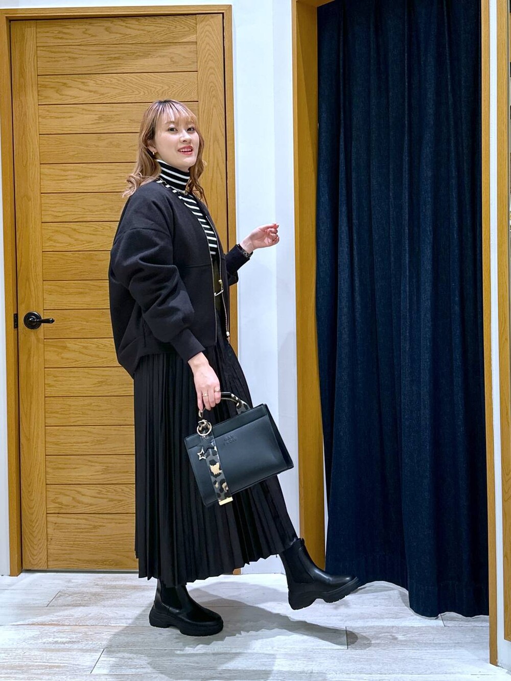 ブラック系のニット/セーター、ブラック系のブーツ、ブラック系のブルゾンを着用したレディースの冬コーディネートの2枚目の写真