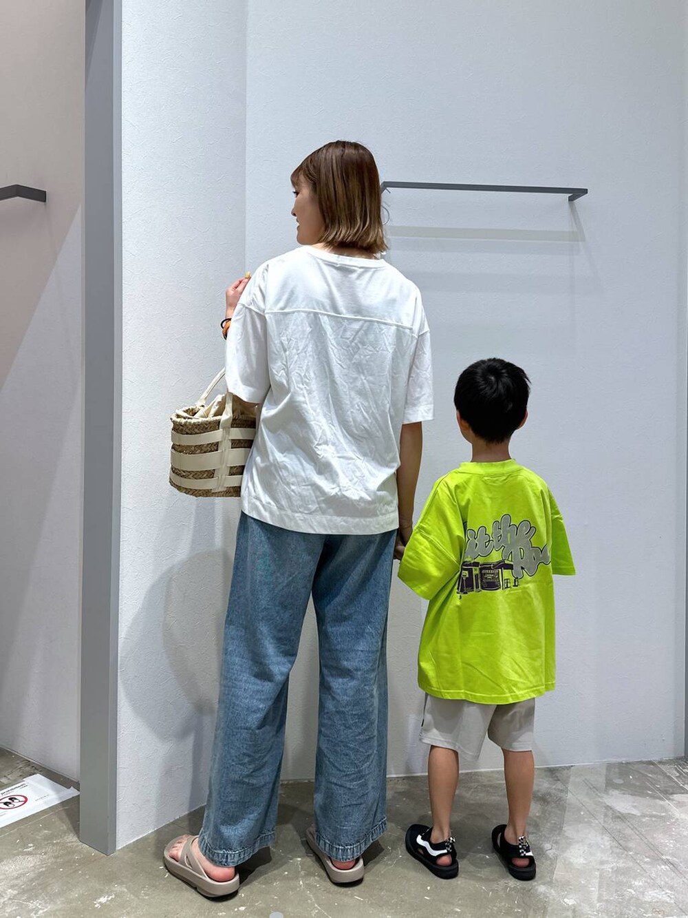 ベージュ系のサンダル、ホワイト系のかごバッグ、ブルー系のデニムパンツを着用したレディースの夏コーディネートの3枚目の写真