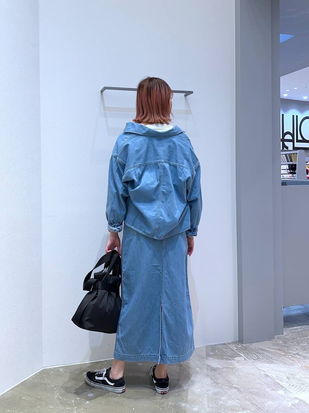 ホワイト系のTシャツ/カットソー、ブラック系のトートバッグ、ブルー系のシャツ/ブラウスを着用したレディースの春コーディネートの3枚目の写真