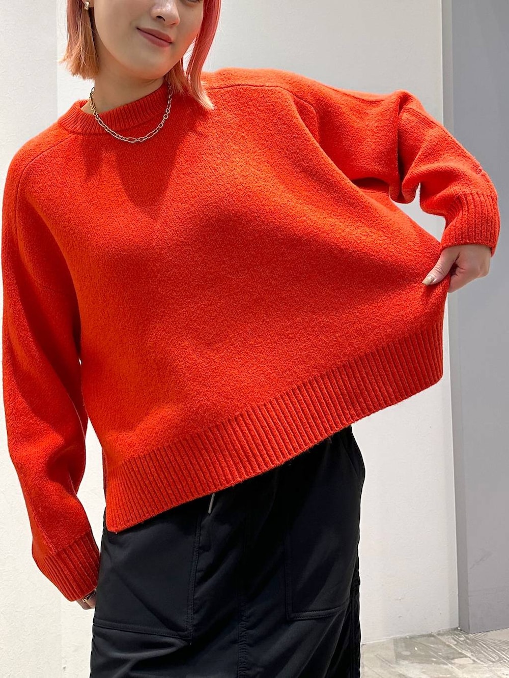 ブラック系のスカート、レッド系のニット/セーター、ブラック系のその他アウターを着用したレディースの秋コーディネートの10枚目の写真