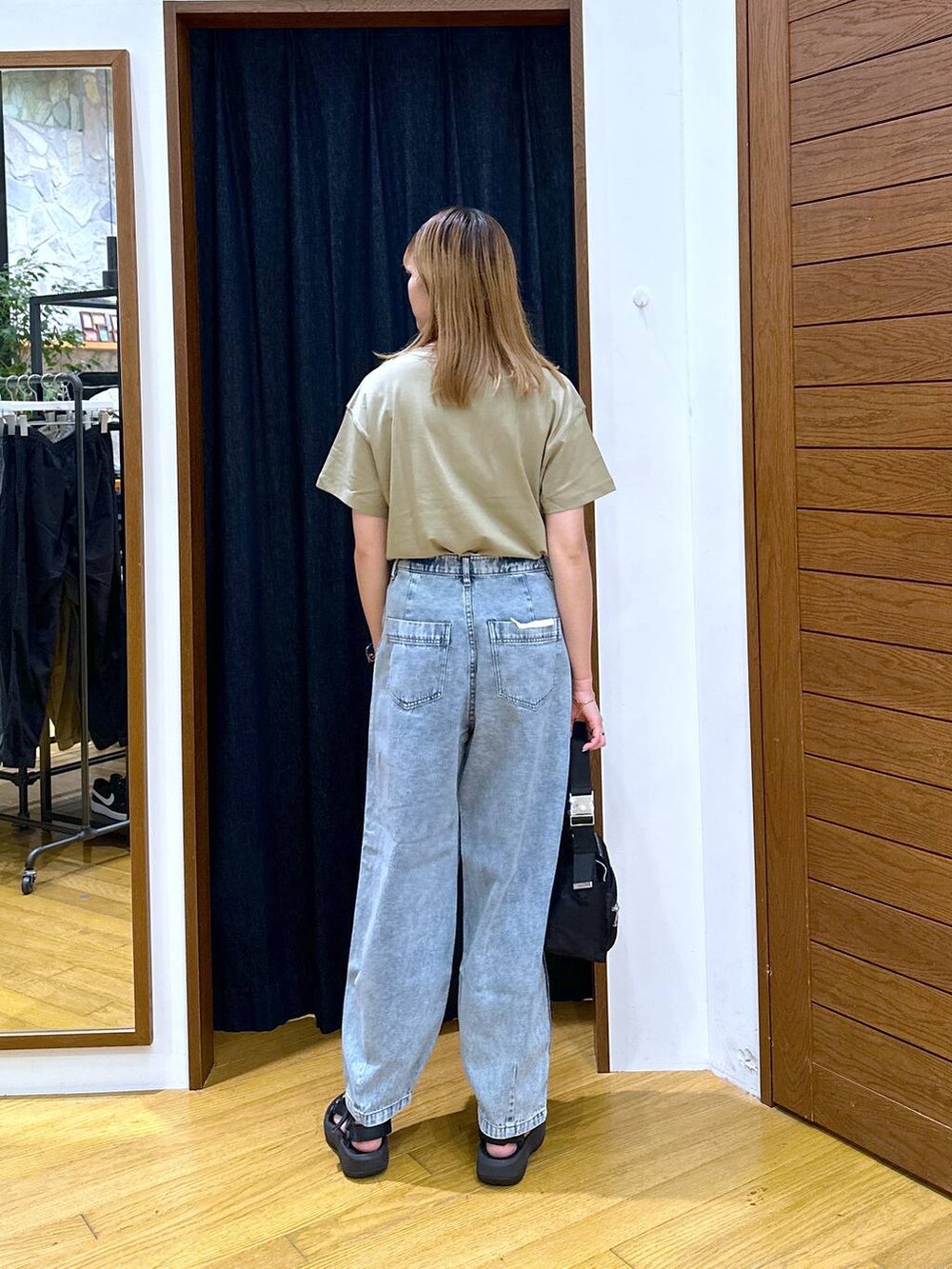 ブラック系のショルダーバッグ、グリーン系のTシャツ/カットソー、ブラック系のサンダルを着用したレディースの夏コーディネートの3枚目の写真
