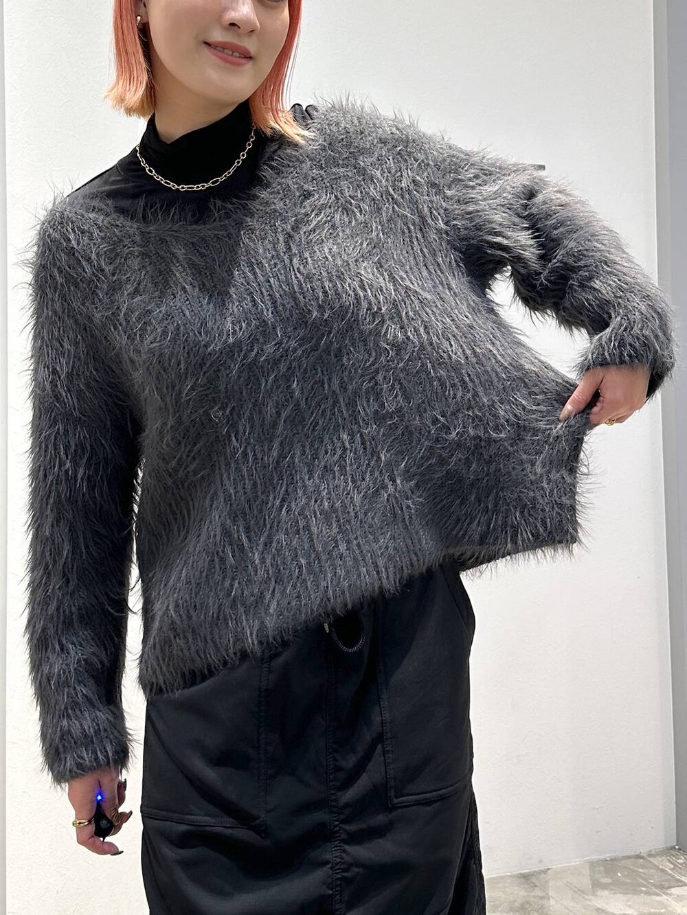 ブラック系のスカート、ブラック系のブーツ、ブラック系のTシャツ/カットソーを着用したレディースの秋コーディネートの4枚目の写真