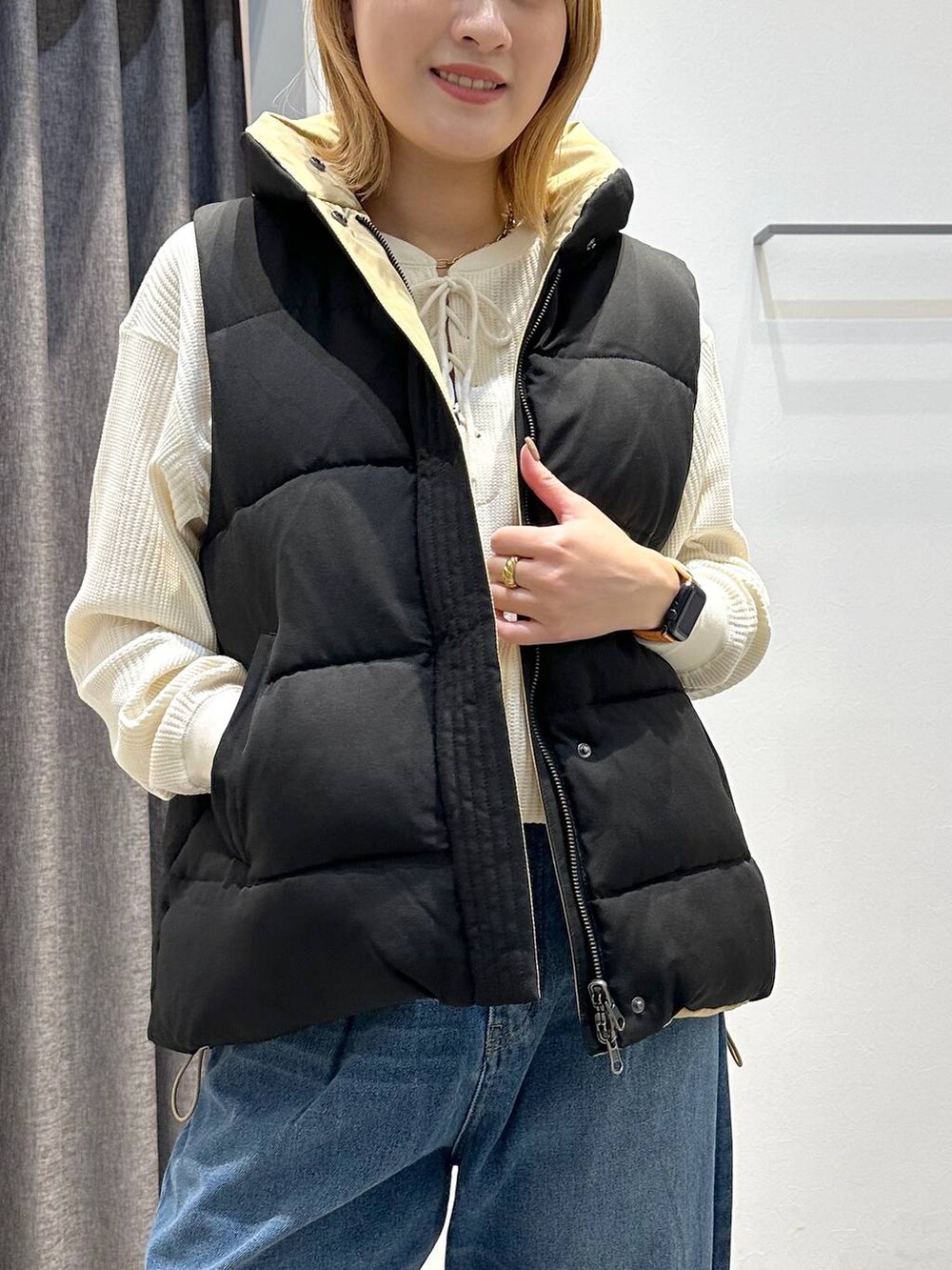 ベージュ系のトートバッグ、ブラック系のベスト、ホワイト系のTシャツ/カットソーを着用したレディースの秋コーディネートの6枚目の写真