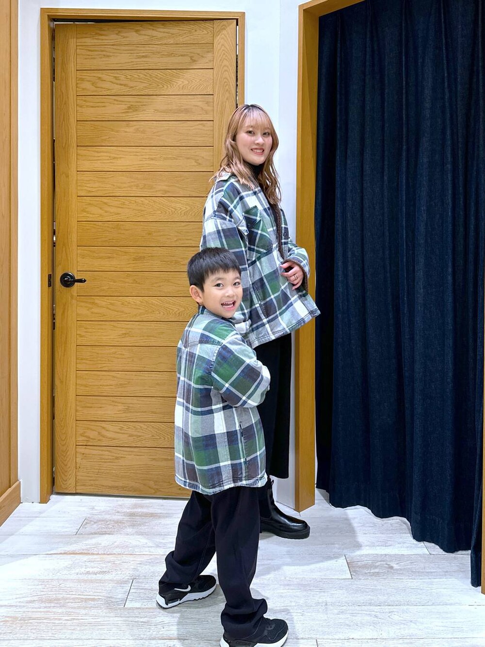 ホワイト系のシャツ/ブラウス、ブラック系のニット/セーター、ブラック系のブーツを着用したレディースの冬コーディネートの2枚目の写真