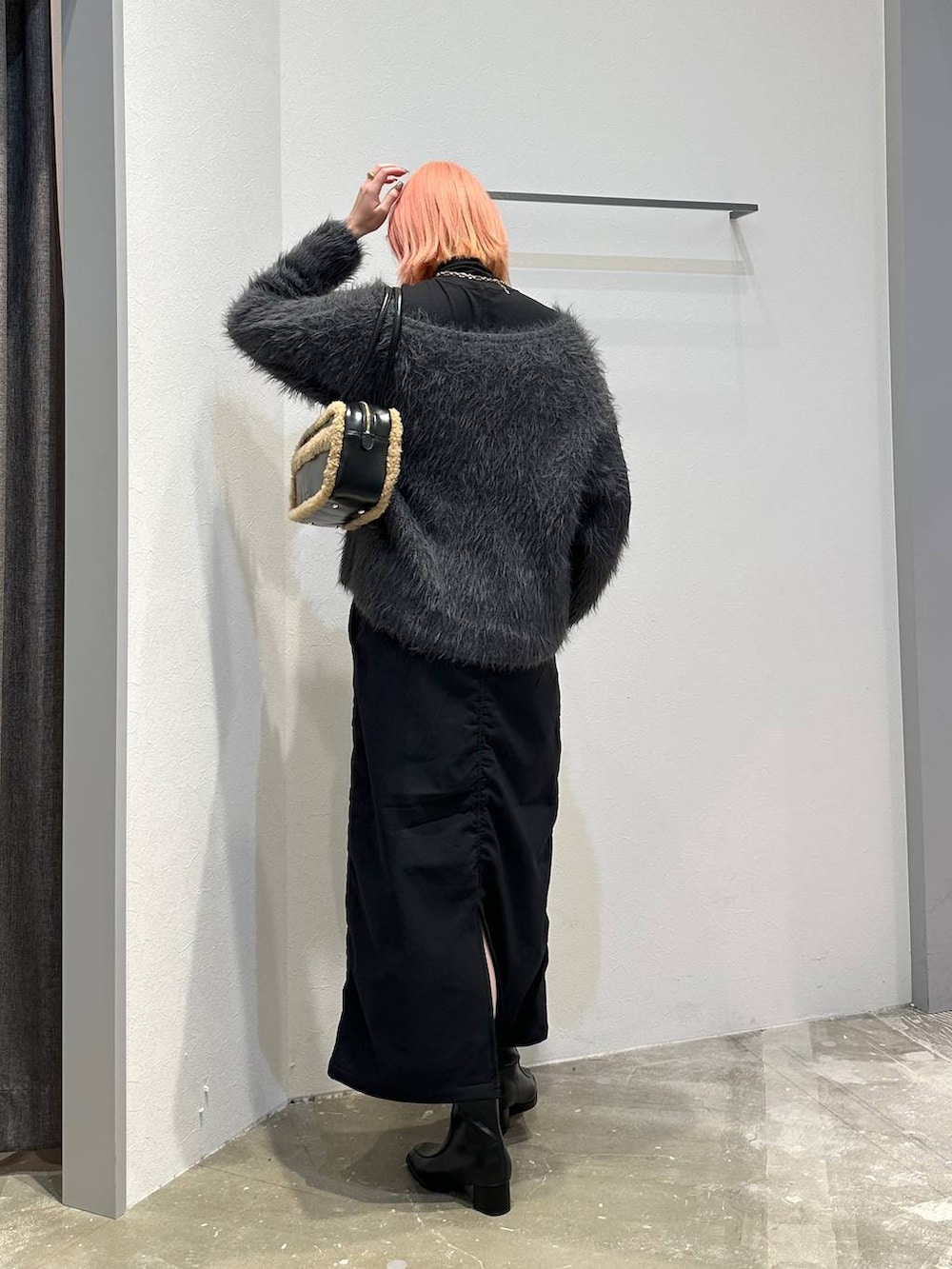 ブラック系のスカート、ブラック系のブーツ、ブラック系のTシャツ/カットソーを着用したレディースの秋コーディネートの3枚目の写真