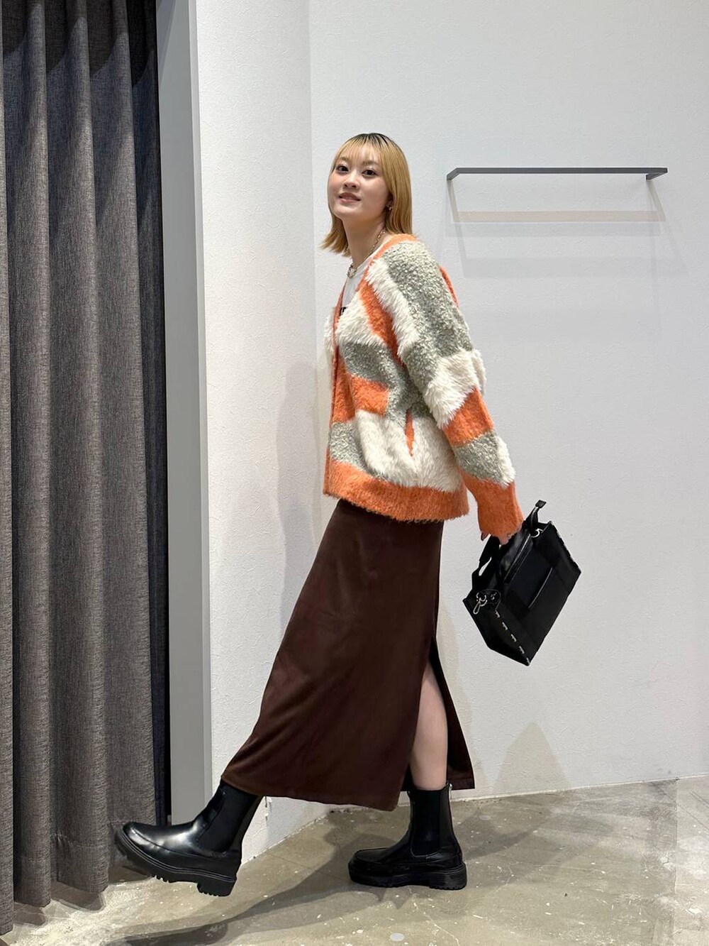 ホワイト系のTシャツ/カットソー、ブラウン系のスカート、ブラック系のトートバッグを着用したレディースの秋コーディネートの2枚目の写真