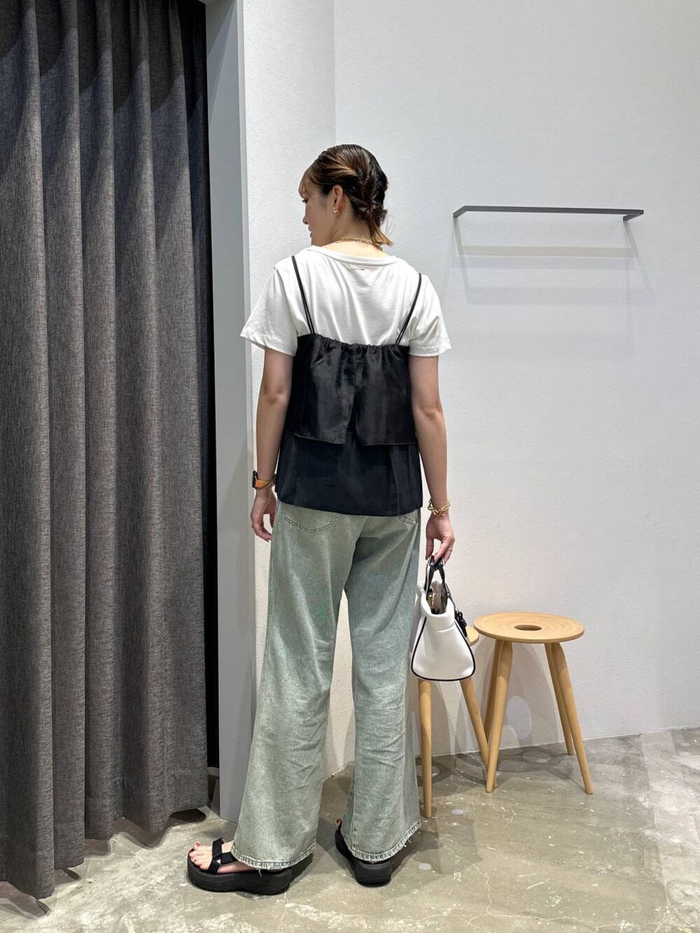 ホワイト系のショルダーバッグ、ブルー系のデニムパンツ、ブラック系のその他トップスを着用したレディースの夏コーディネートの3枚目の写真