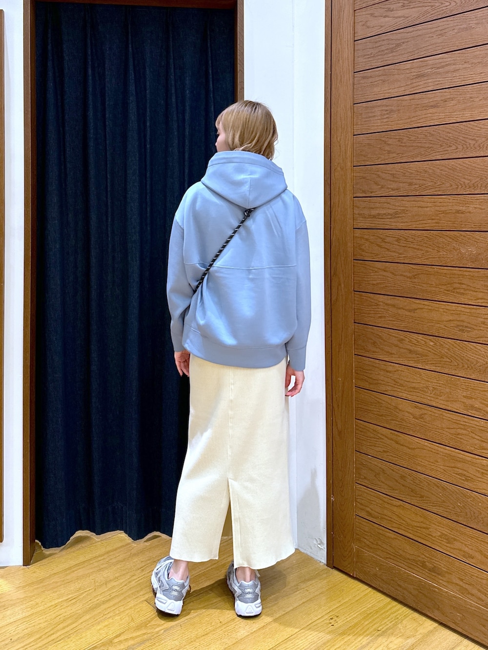 ブルー系のパーカー、グレー系のショルダーバッグ、ベージュ系のスカートを着用したレディースの春コーディネートの3枚目の写真