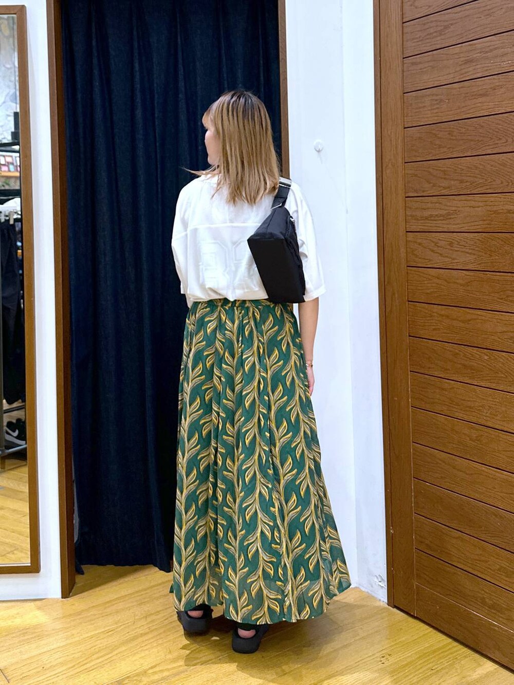 グリーン系のスカート、ブラック系のショルダーバッグ、ブラック系のサンダルを着用したレディースの夏コーディネートの3枚目の写真