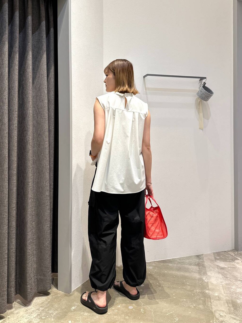 レッド系のハンドバッグ、ホワイト系のシャツ/ブラウス、ブラック系のその他パンツを着用したレディースの夏コーディネートの3枚目の写真