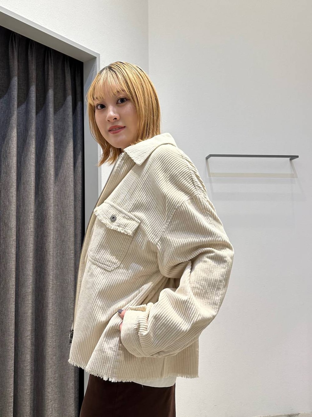 ブラウン系のスカート、ホワイト系のTシャツ/カットソー、ホワイト系のブルゾンを着用したレディースの秋コーディネートの6枚目の写真