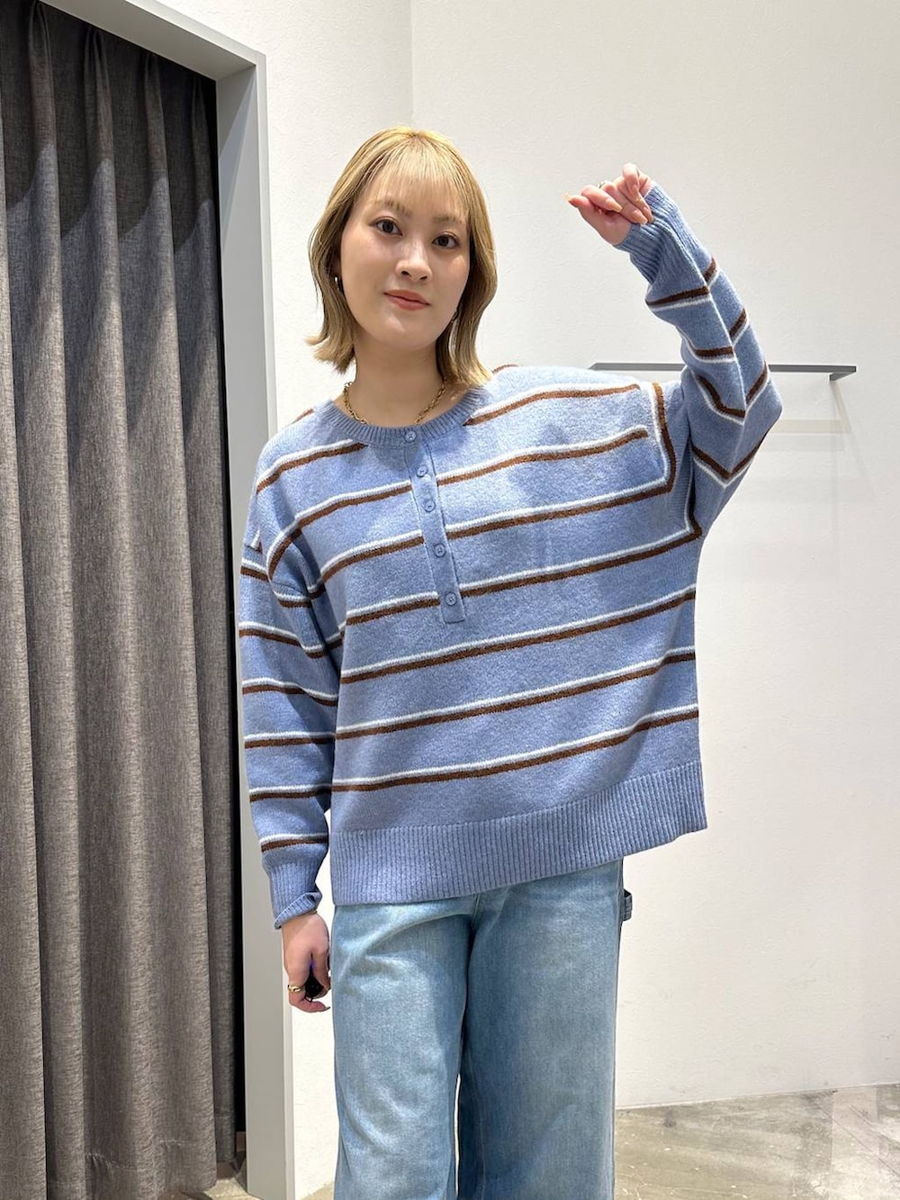 ブルー系のニット/セーター、ブルー系のデニムパンツ、ブラック系のバックパック/リュックを着用したレディースの冬コーディネートの4枚目の写真