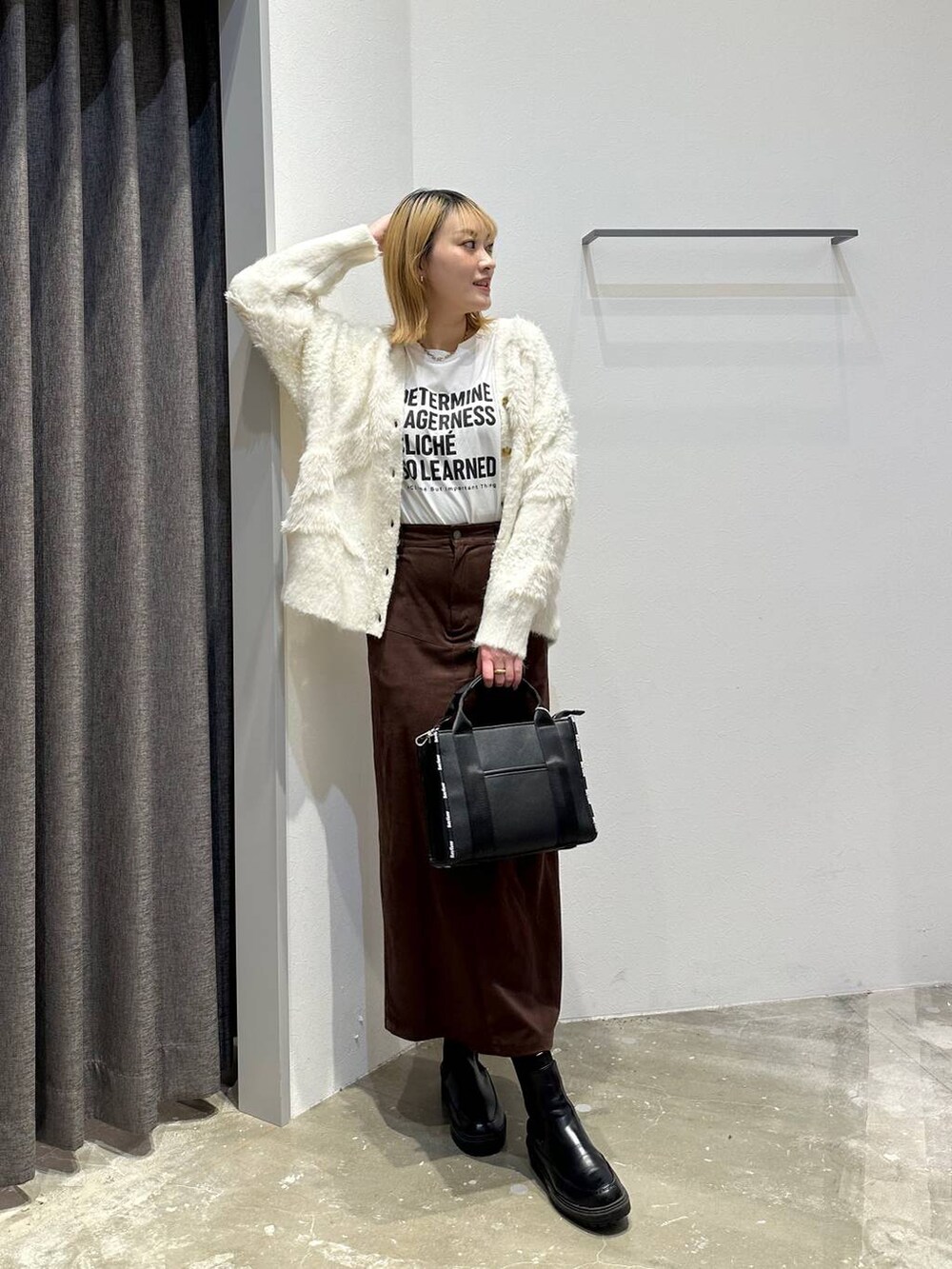 ホワイト系のTシャツ/カットソー、ブラウン系のスカート、ブラック系のトートバッグを着用したレディースの秋コーディネートの9枚目の写真