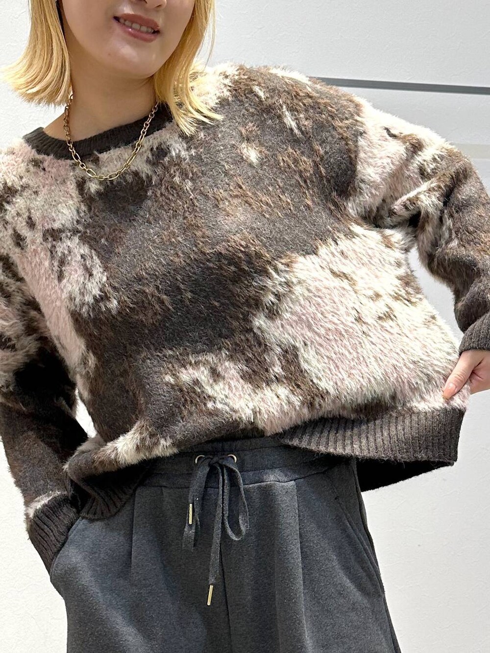 ブラウン系のニット/セーター、グレー系のスウェットパンツを着用したレディースの冬コーディネートの6枚目の写真