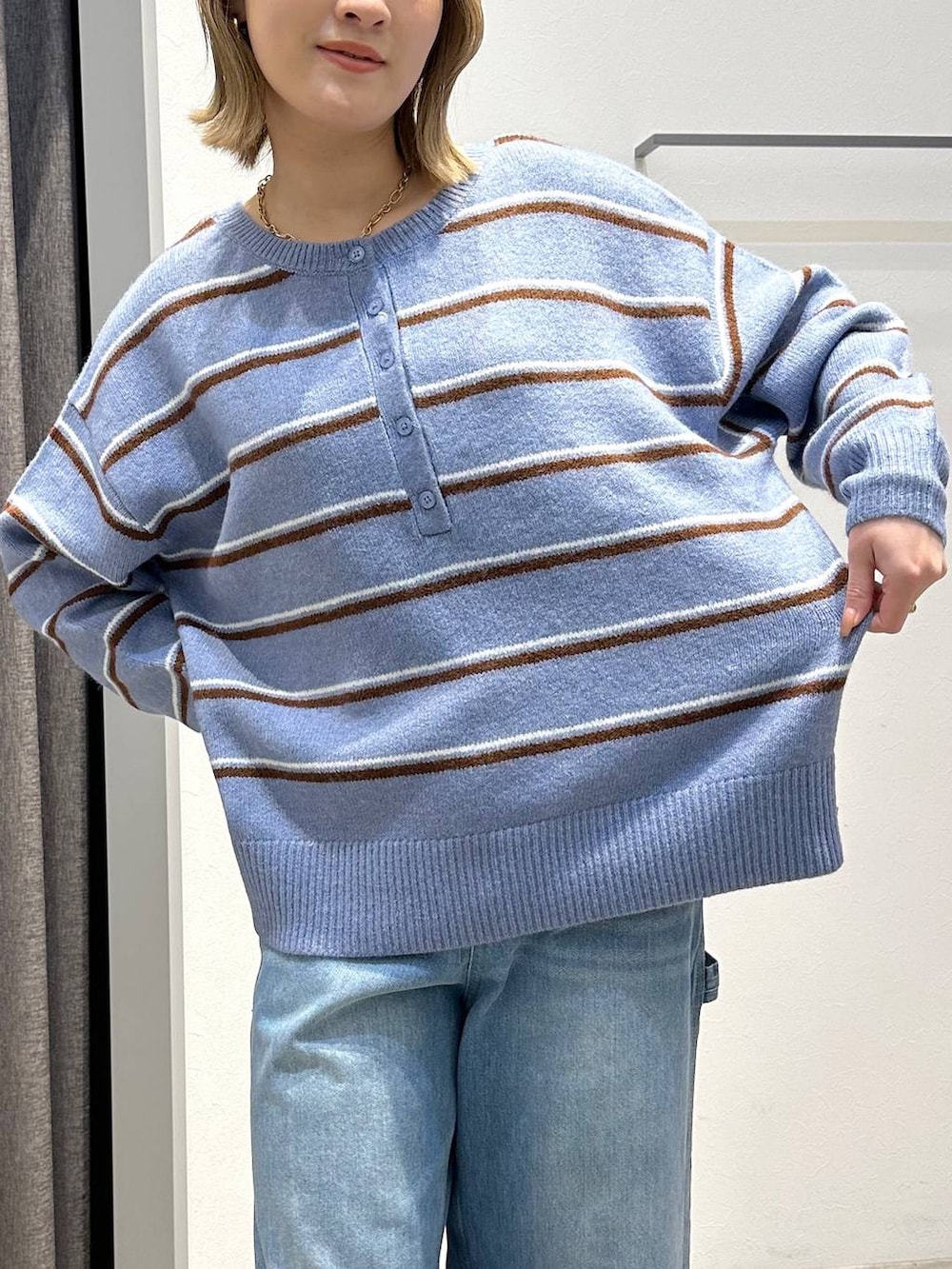 ブルー系のニット/セーター、ブルー系のデニムパンツ、ブラック系のバックパック/リュックを着用したレディースの冬コーディネートの5枚目の写真