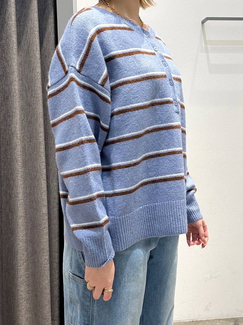 ブルー系のニット/セーター、ブルー系のデニムパンツ、ブラック系のバックパック/リュックを着用したレディースの冬コーディネートの7枚目の写真