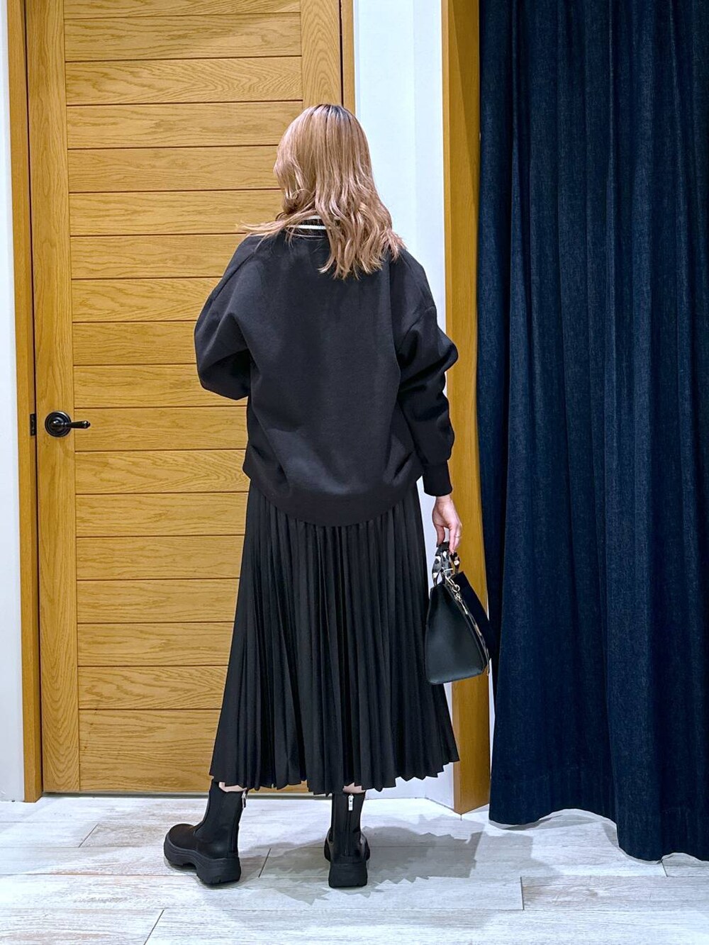 ブラック系のニット/セーター、ブラック系のブーツ、ブラック系のブルゾンを着用したレディースの冬コーディネートの3枚目の写真