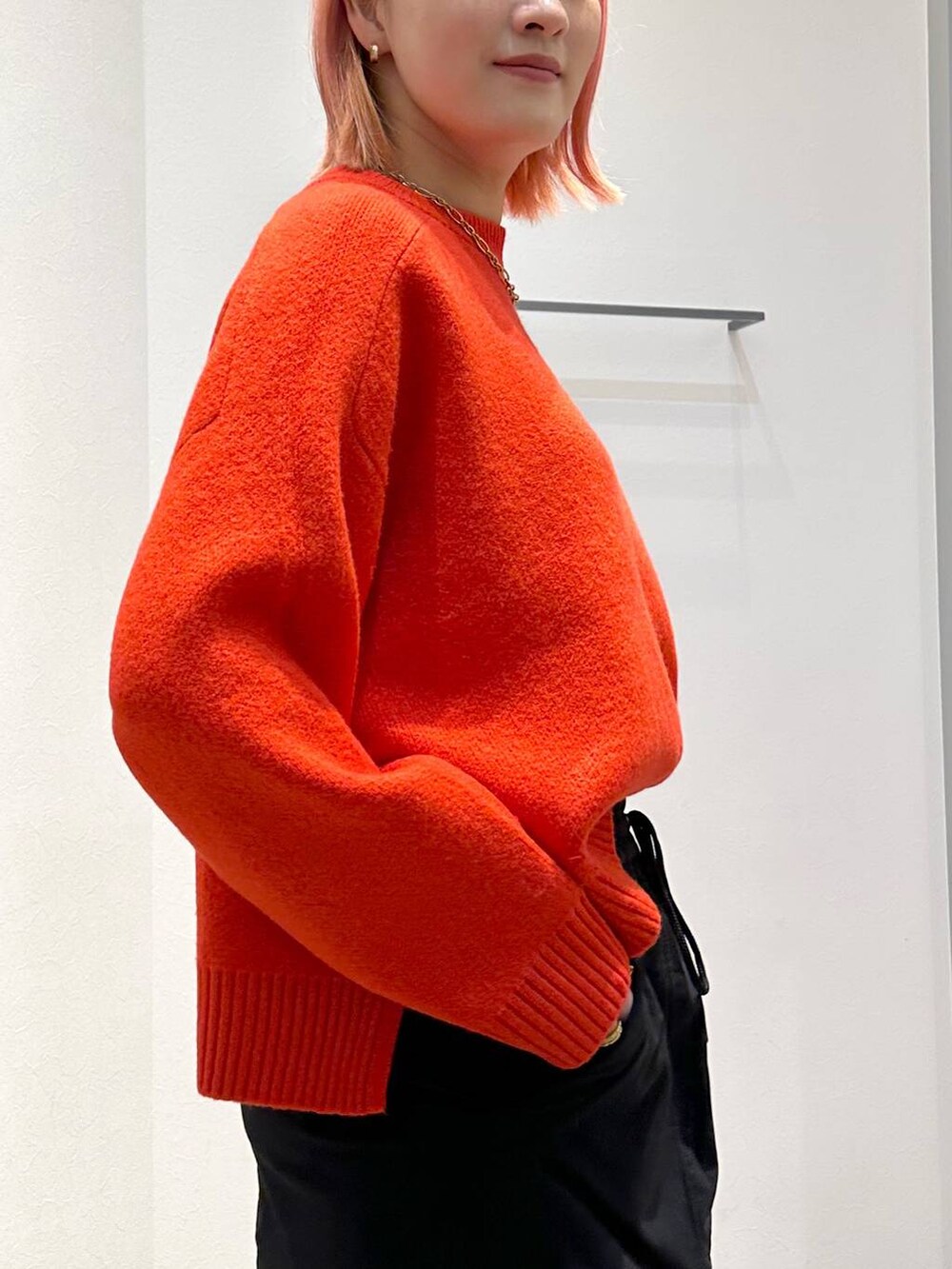 ブラック系のスカート、レッド系のニット/セーター、ブラック系のその他アウターを着用したレディースの秋コーディネートの8枚目の写真