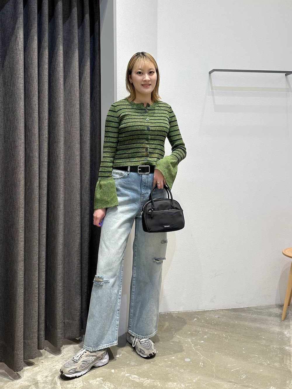 ブルー系のデニムパンツ、グリーン系のニット/セーター、ブラック系のベルトを着用したレディースの春コーディネートの8枚目の写真