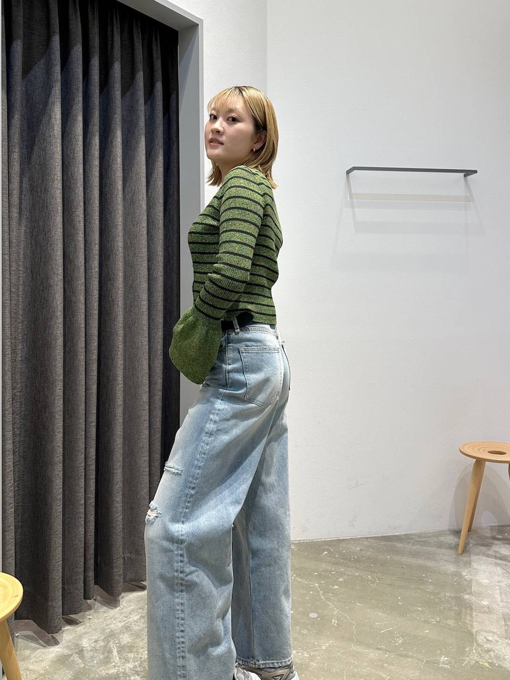 ブルー系のデニムパンツ、グリーン系のニット/セーター、ブラック系のベルトを着用したレディースの春コーディネートの7枚目の写真