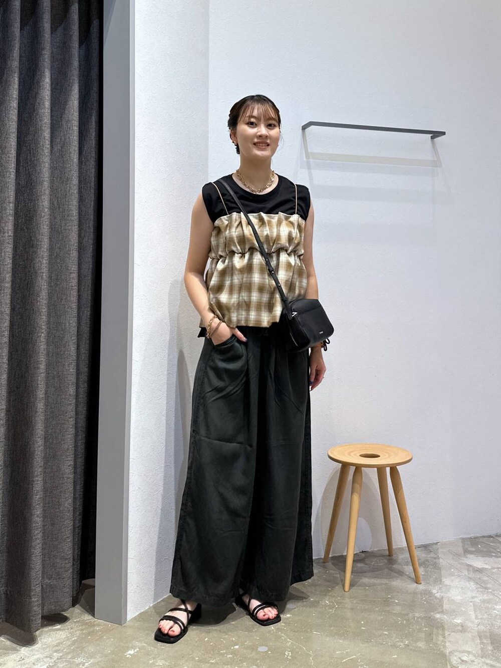 ブラック系のTシャツ/カットソー、グレー系のその他パンツ、ブラック系のサンダルを着用したレディースの秋コーディネートの4枚目の写真