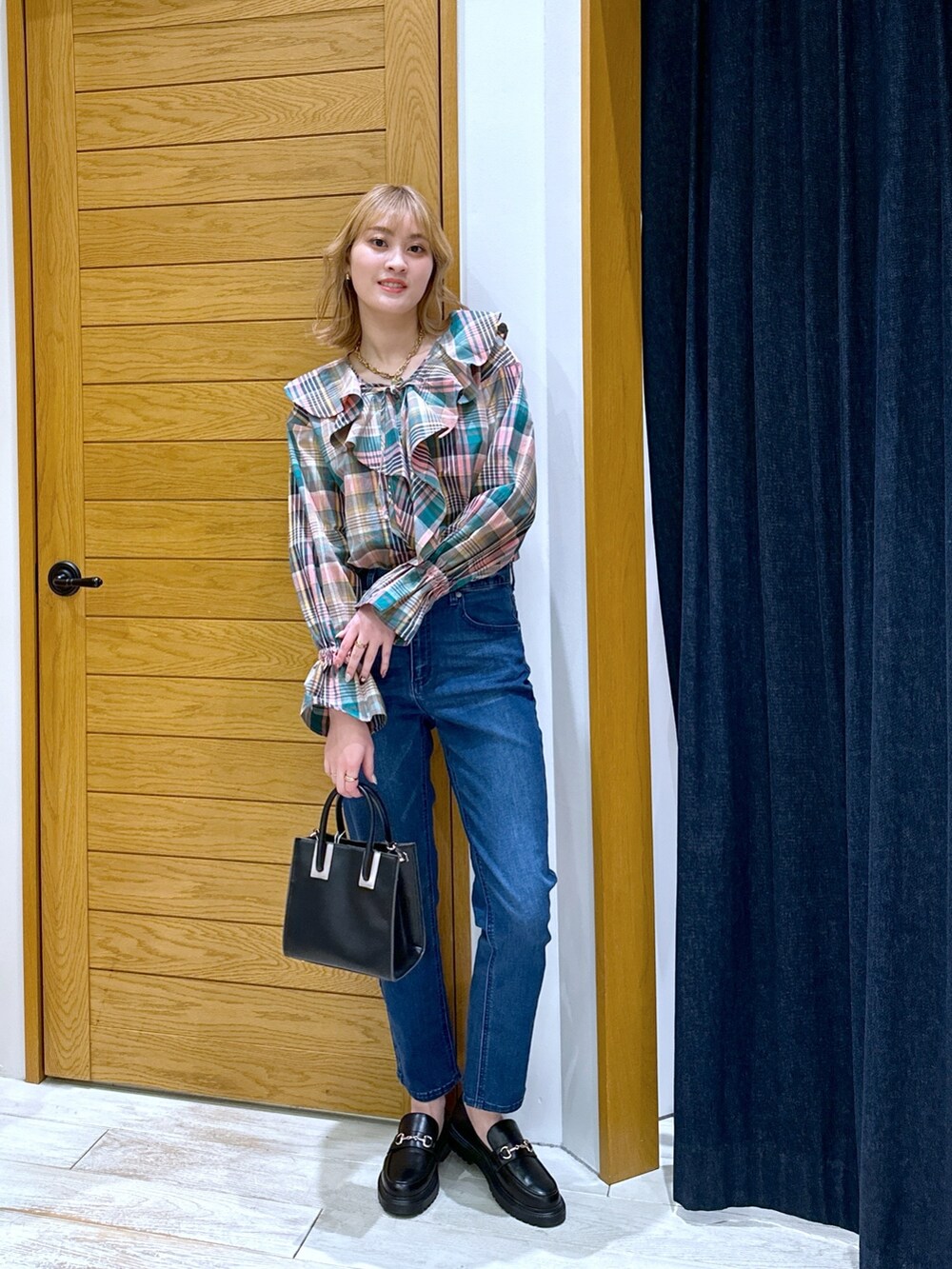 ブラック系のショルダーバッグ、ブルー系のデニムパンツ、ピンク系のシャツ/ブラウスを着用したレディースの冬コーディネートの4枚目の写真