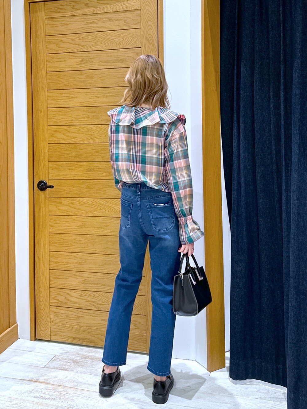 ブラック系のショルダーバッグ、ブルー系のデニムパンツ、ピンク系のシャツ/ブラウスを着用したレディースの冬コーディネートの3枚目の写真