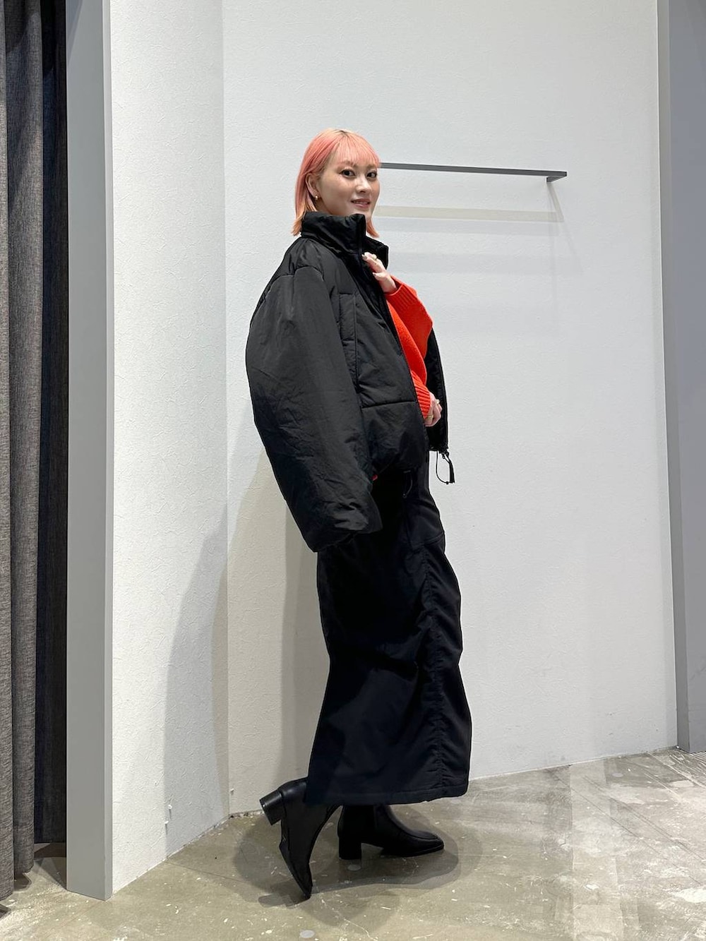 ブラック系のスカート、レッド系のニット/セーター、ブラック系のその他アウターを着用したレディースの秋コーディネートの2枚目の写真