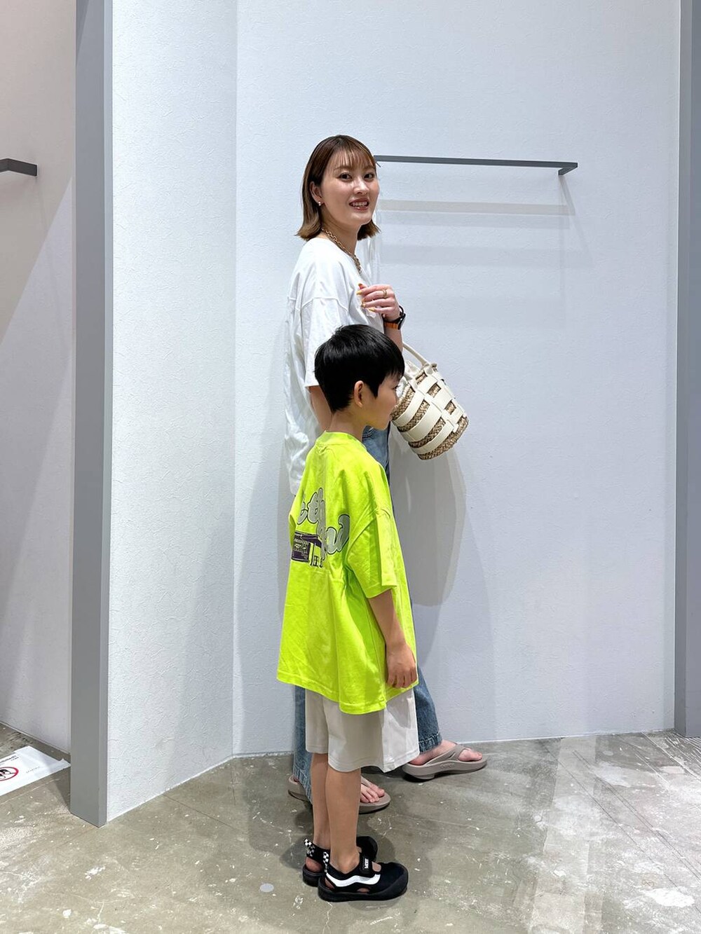 ベージュ系のサンダル、ホワイト系のかごバッグ、ブルー系のデニムパンツを着用したレディースの夏コーディネートの2枚目の写真