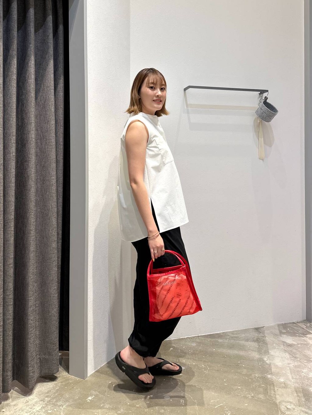 レッド系のハンドバッグ、ホワイト系のシャツ/ブラウス、ブラック系のその他パンツを着用したレディースの夏コーディネートの2枚目の写真