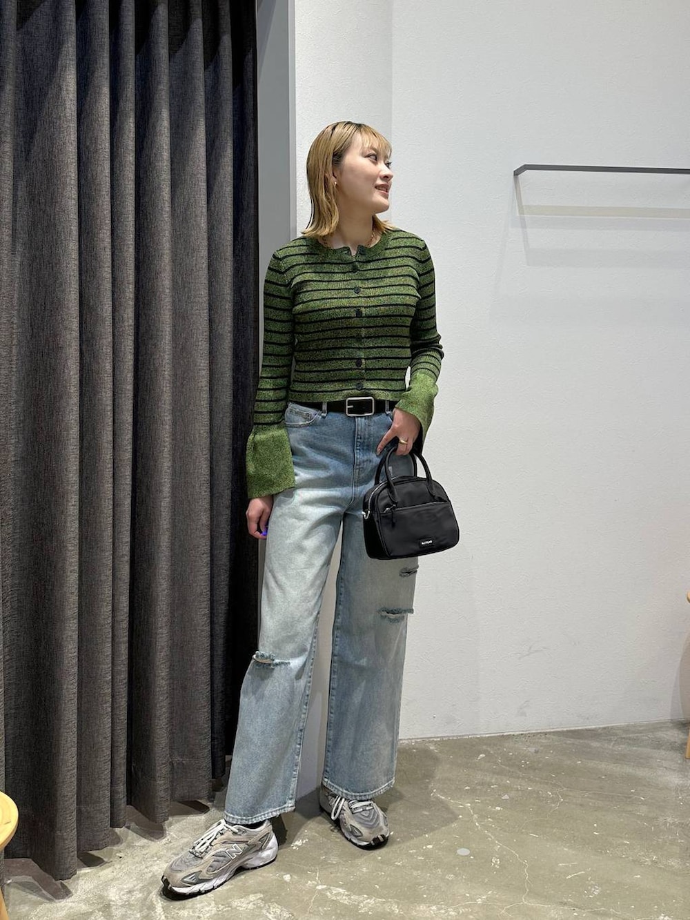 ブルー系のデニムパンツ、グリーン系のニット/セーター、ブラック系のベルトを着用したレディースの春コーディネートの9枚目の写真