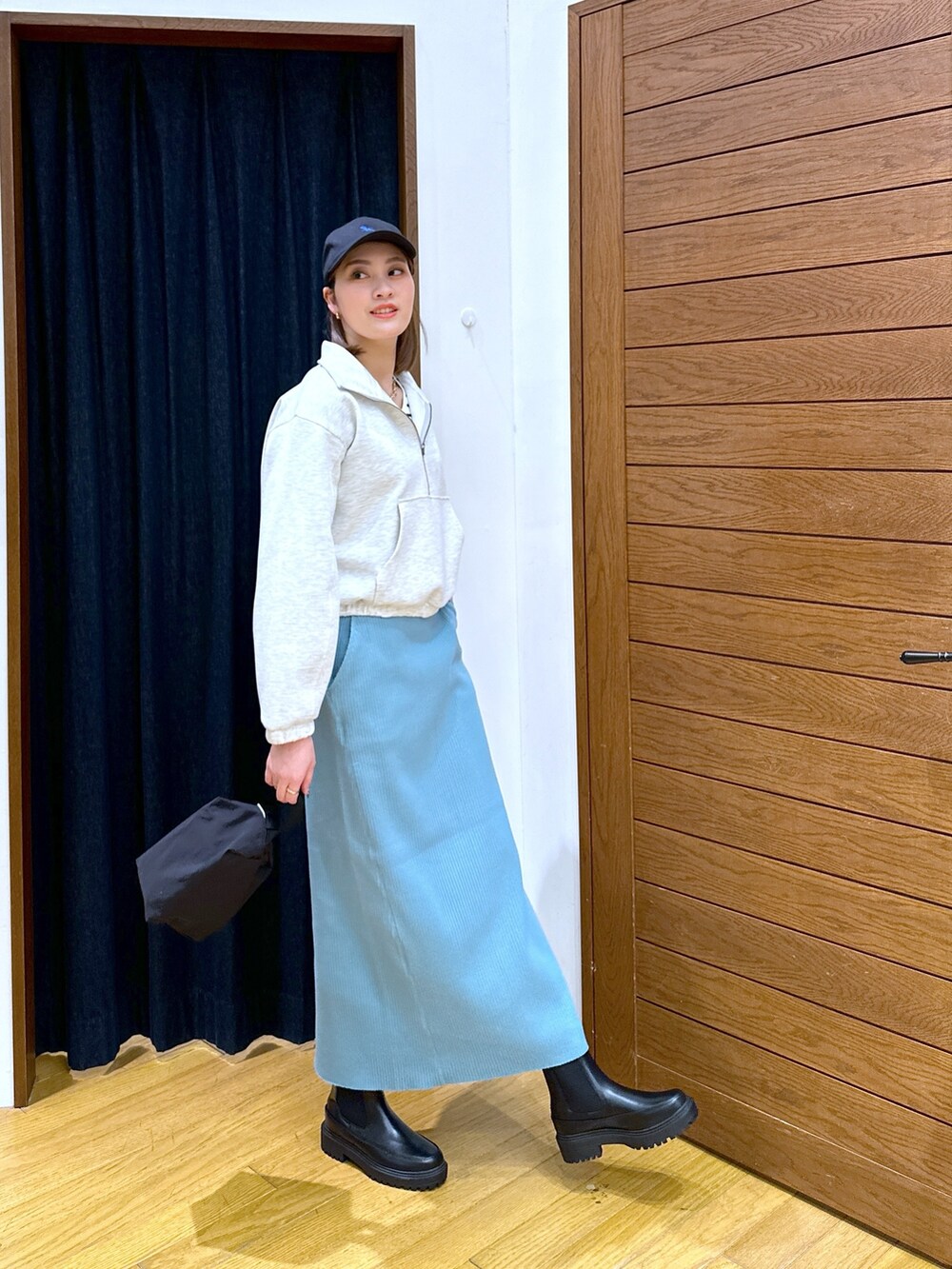 グレー系のスウェット、ホワイト系のTシャツ/カットソー、ブルー系のスカートを着用したレディースの冬コーディネートの2枚目の写真