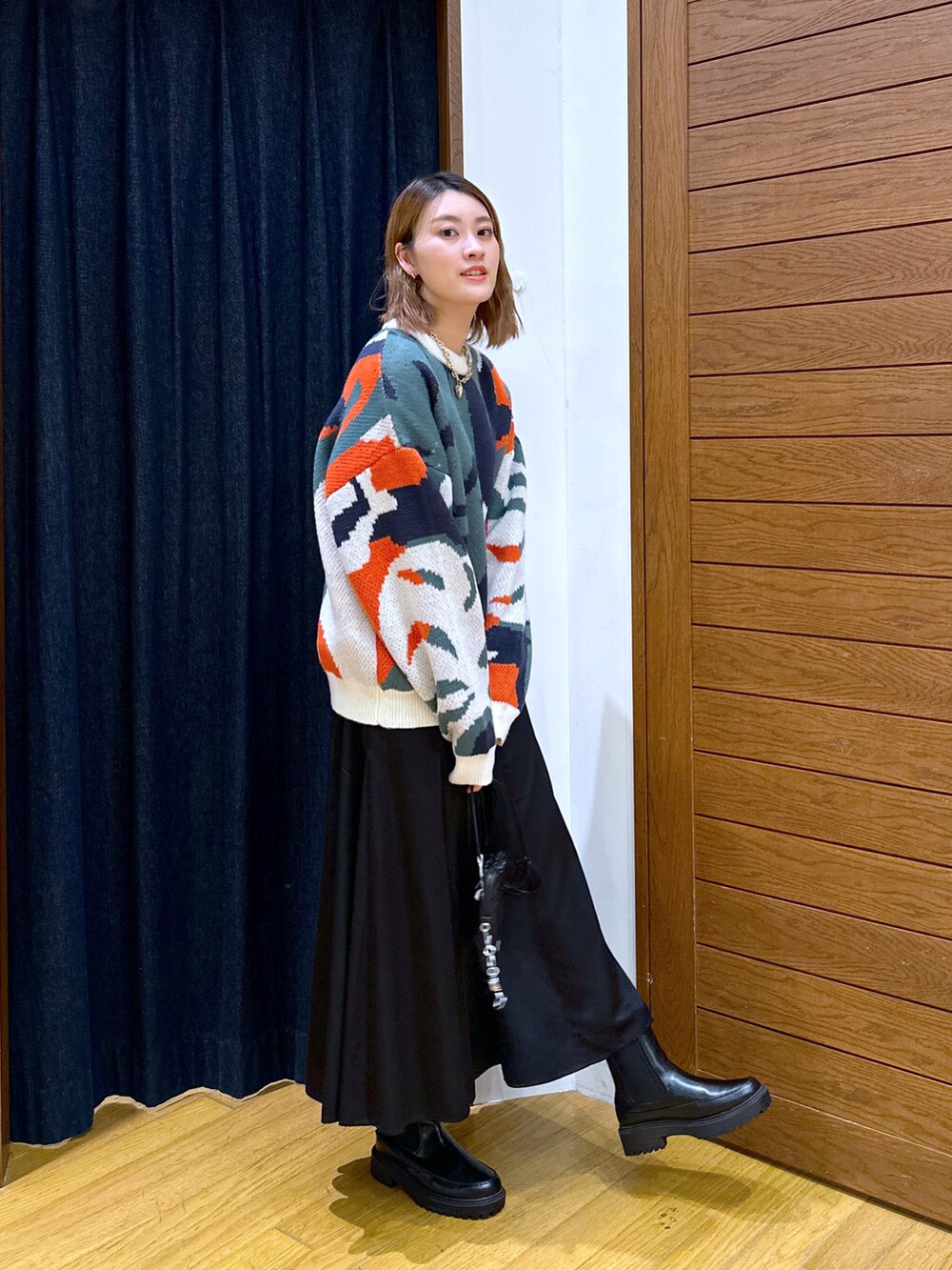 ホワイト系のニット/セーター、ブラック系のショルダーバッグ、ブラック系のスカートを着用したレディースの秋コーディネートの3枚目の写真