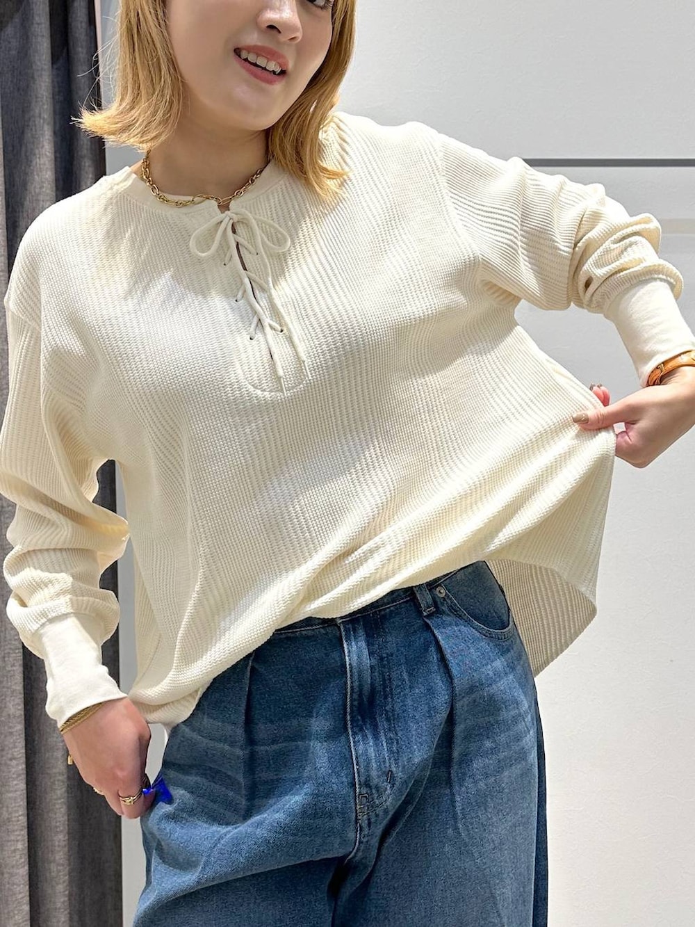 ベージュ系のトートバッグ、ブラック系のベスト、ホワイト系のTシャツ/カットソーを着用したレディースの秋コーディネートの8枚目の写真