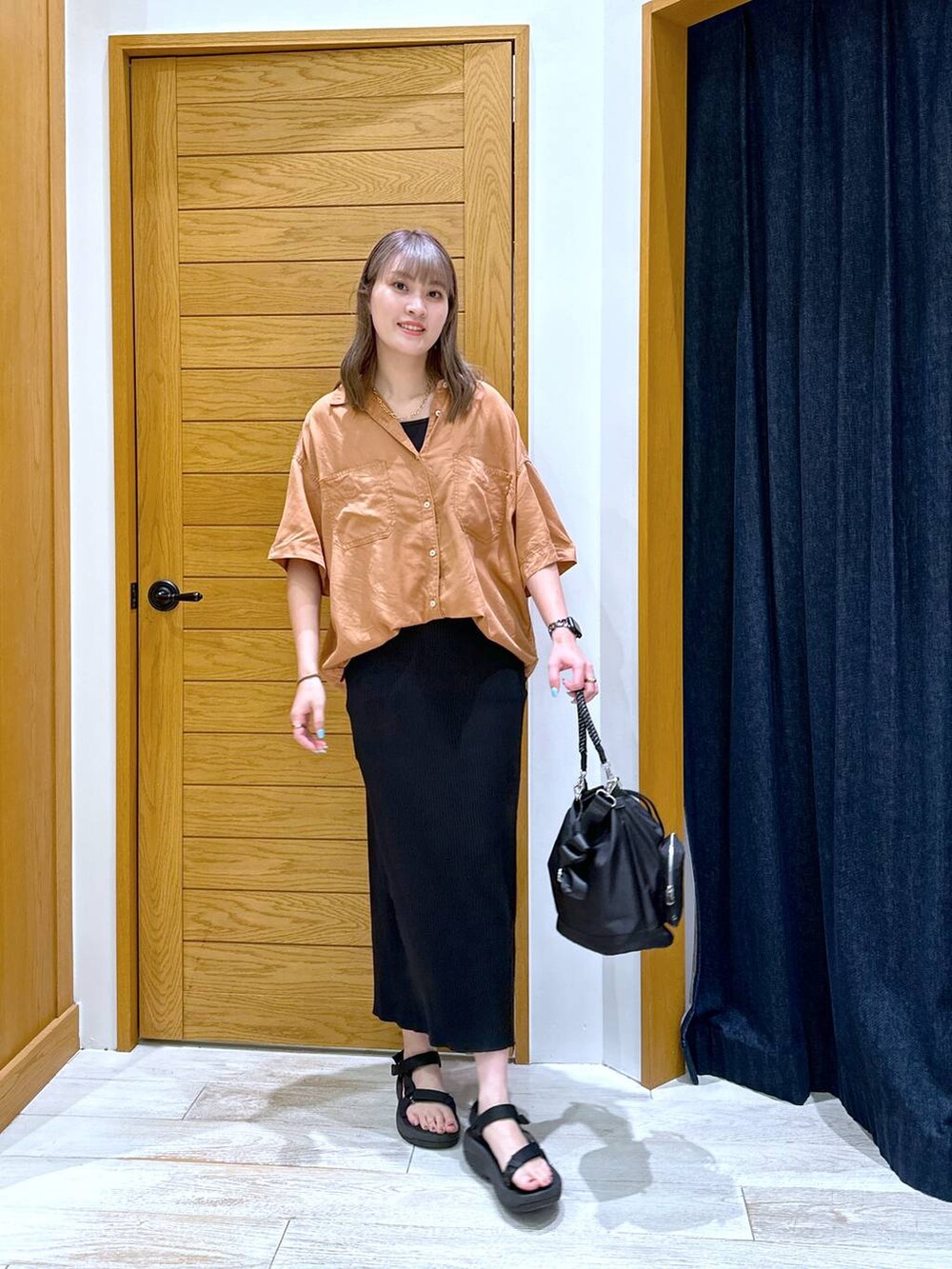 ブラック系のスカート、ブラック系のサンダル、レッド系のシャツ/ブラウスを着用したレディースの夏コーディネートの4枚目の写真