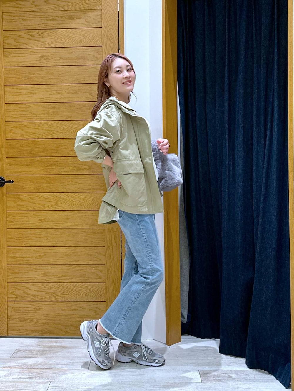 ブラウン系のマウンテンパーカー、ブルー系のデニムパンツ、ホワイト系のTシャツ/カットソーを着用したレディースの秋コーディネートの2枚目の写真