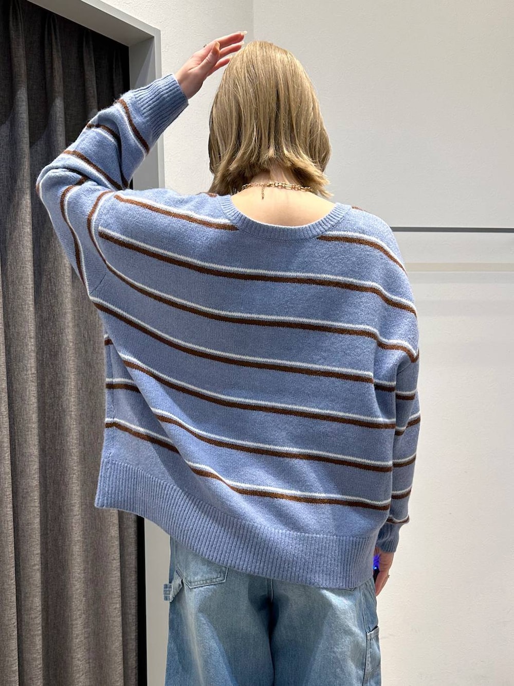 ブルー系のニット/セーター、ブルー系のデニムパンツ、ブラック系のバックパック/リュックを着用したレディースの冬コーディネートの6枚目の写真