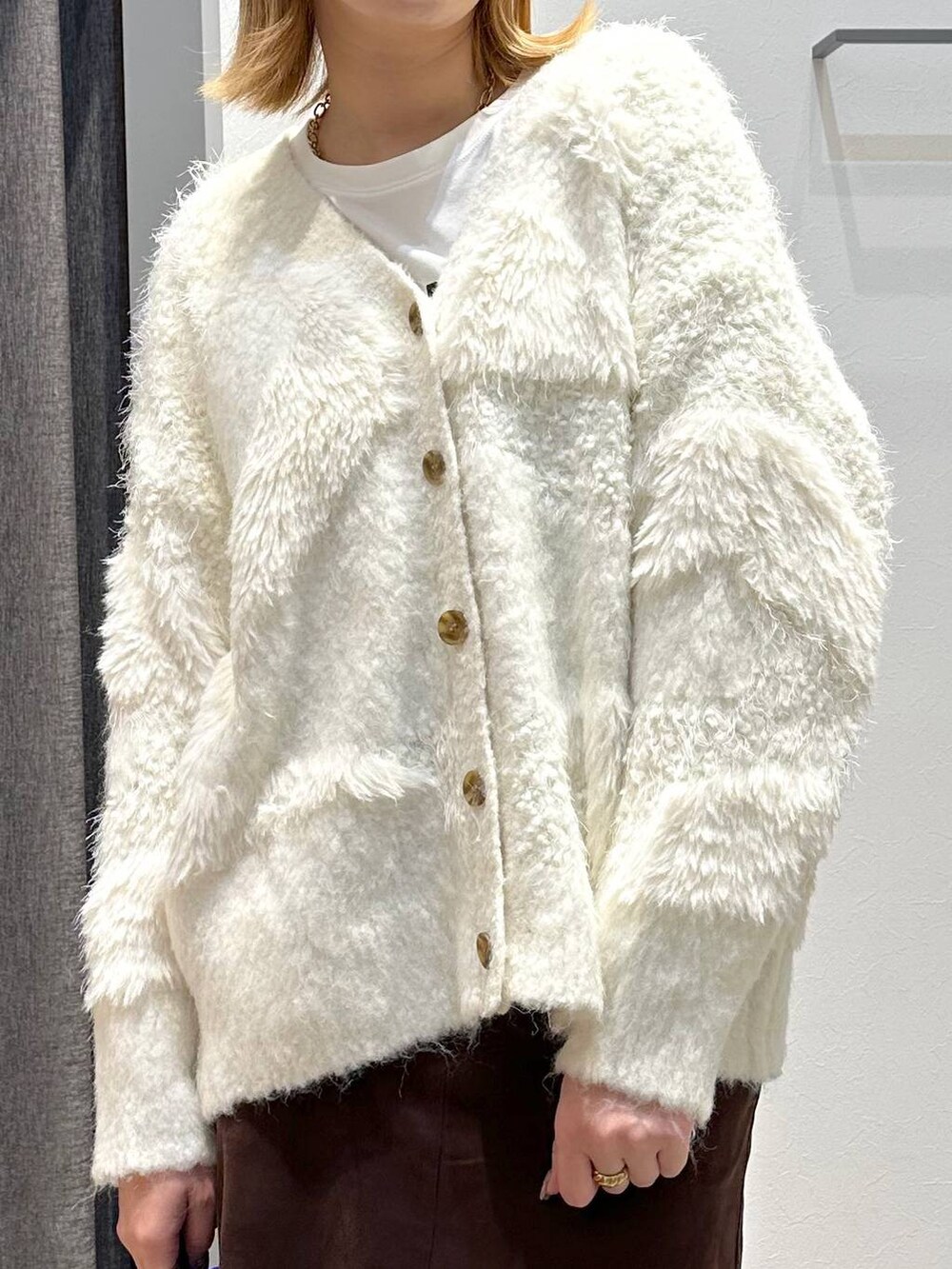 ホワイト系のTシャツ/カットソー、ブラウン系のスカート、ブラック系のトートバッグを着用したレディースの秋コーディネートの6枚目の写真