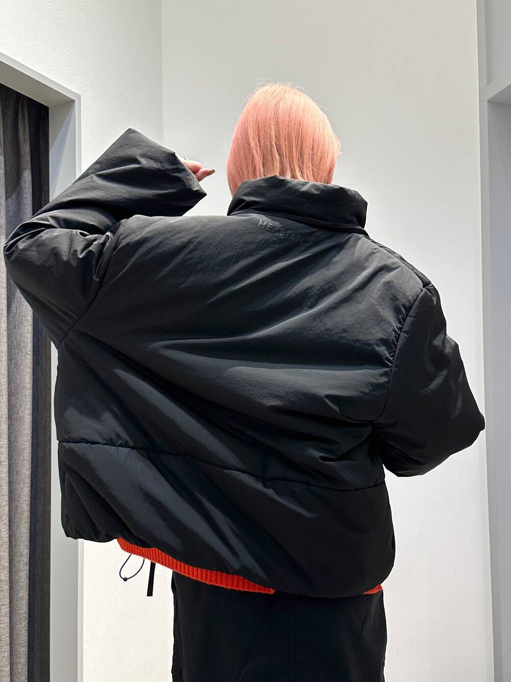 ブラック系のスカート、レッド系のニット/セーター、ブラック系のその他アウターを着用したレディースの秋コーディネートの6枚目の写真